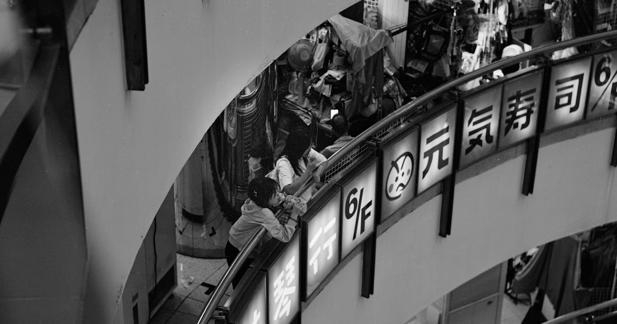 A black and white photo of an escalator in a building
