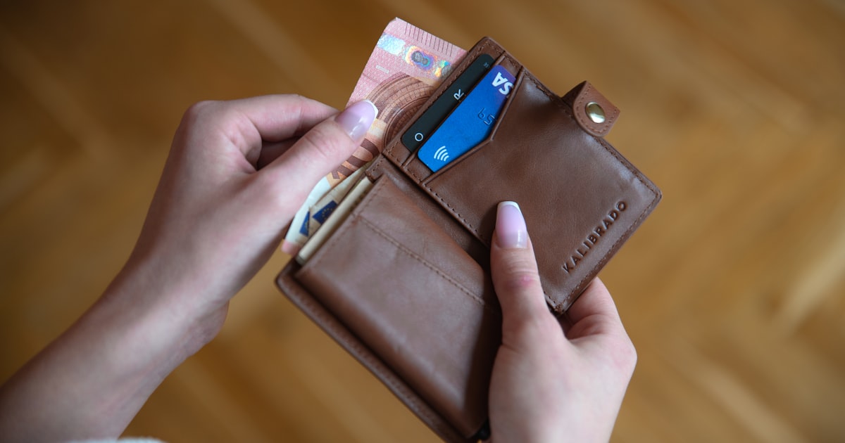 person holding brown leather card wallet