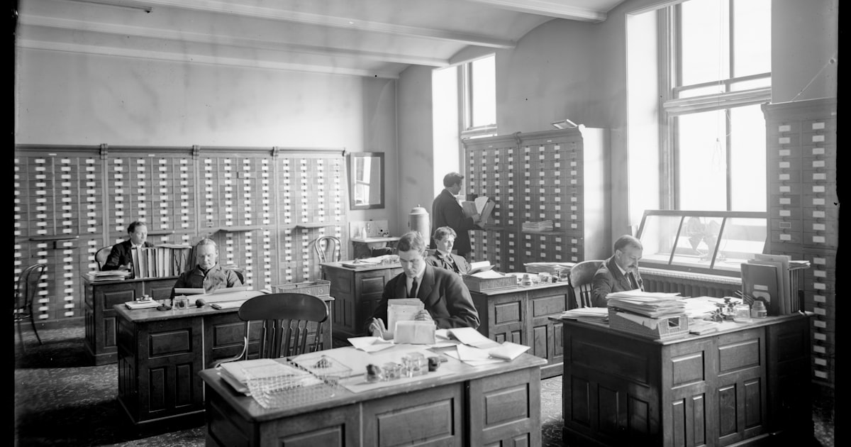 Men working in a vintage office with card catalogs