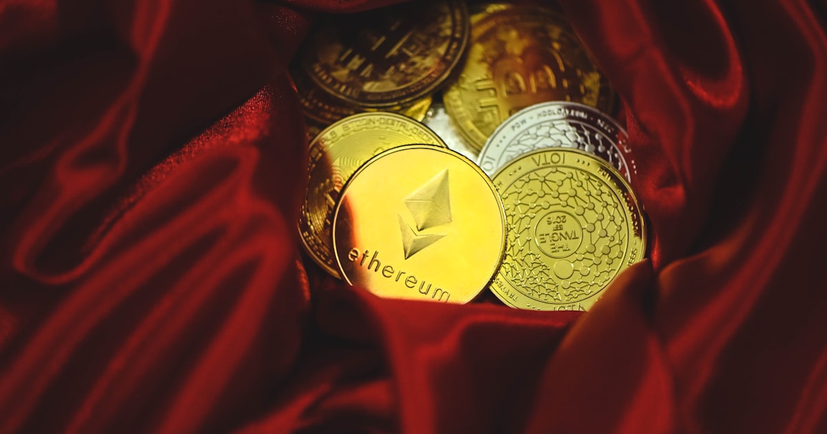a pile of gold and silver coins sitting on top of a red cloth