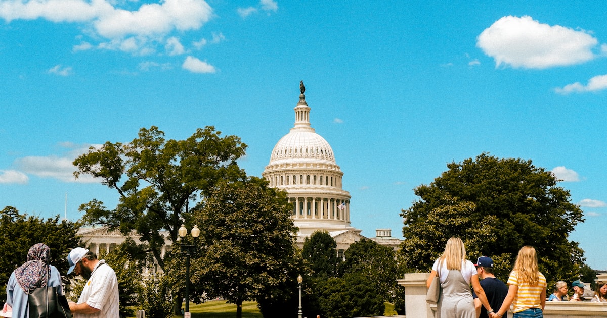 A group of people standing in front of the capitol building