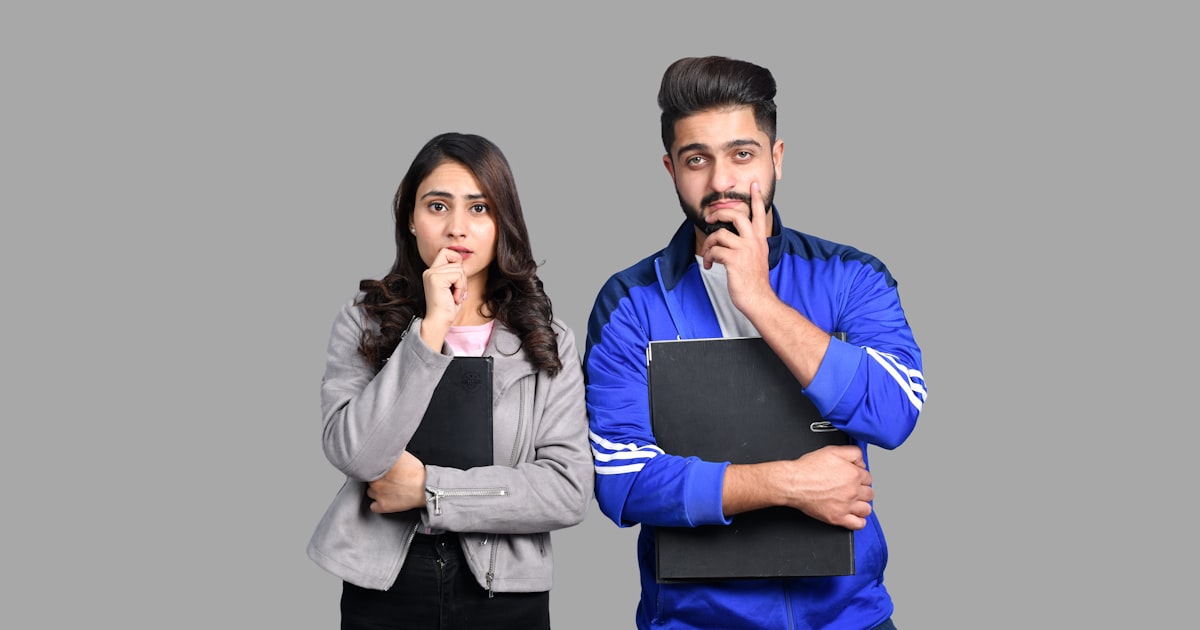a man and a woman holding a laptop and a book