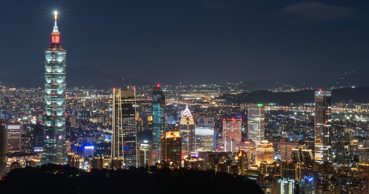 A view of a city at night from the top of a hill