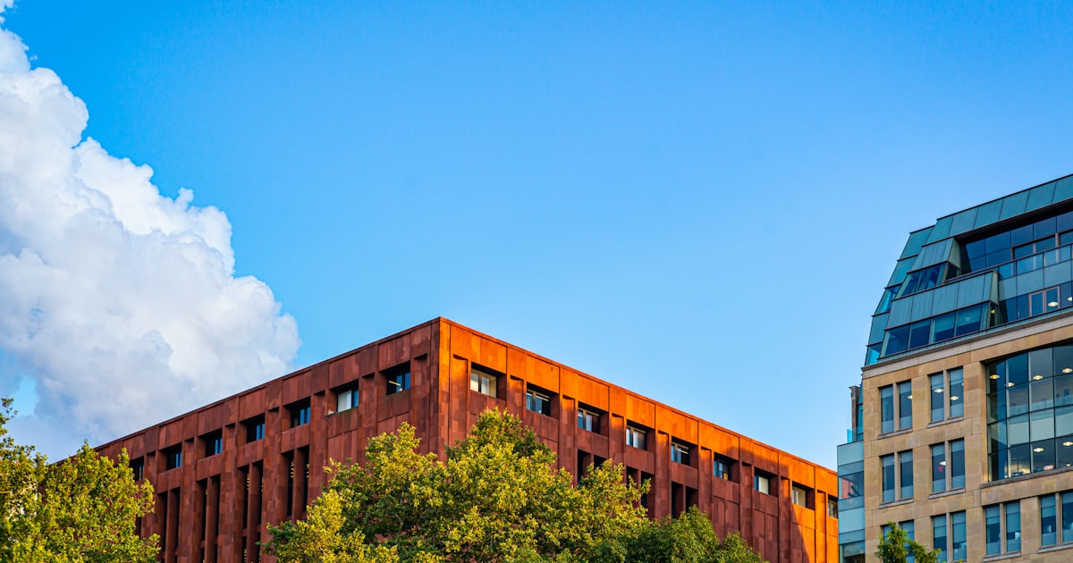 brown concrete building under white clouds during daytime