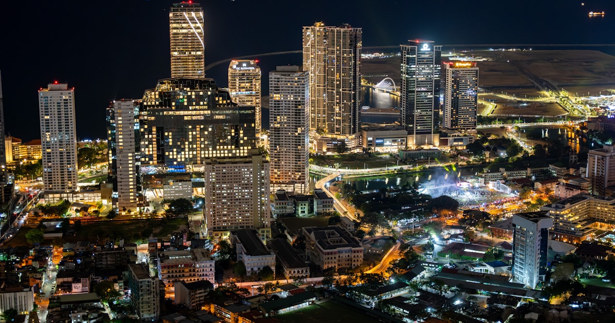 Vibrant cityscape at night with illuminated skyscrapers and city lights.