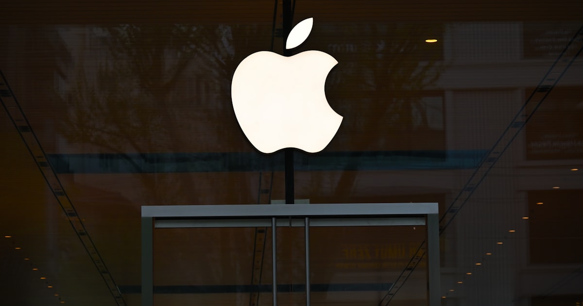 the apple logo is reflected in the glass of a building