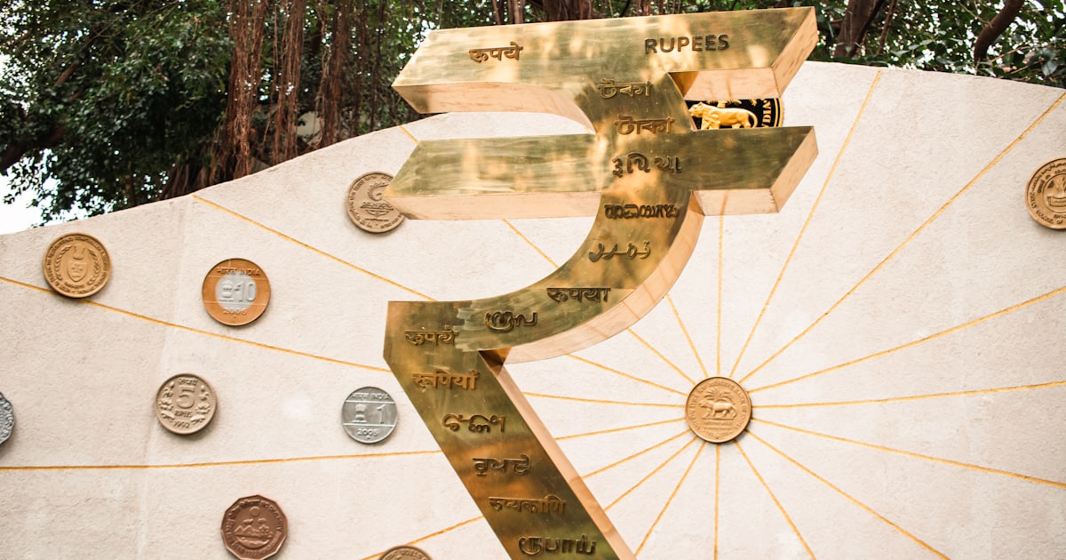 A monument displays the symbol for the indian rupee.