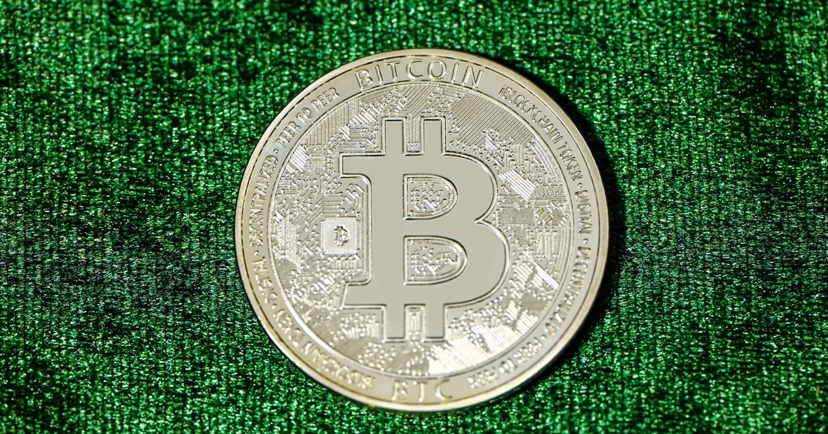 a bit coin sitting on top of a green cloth