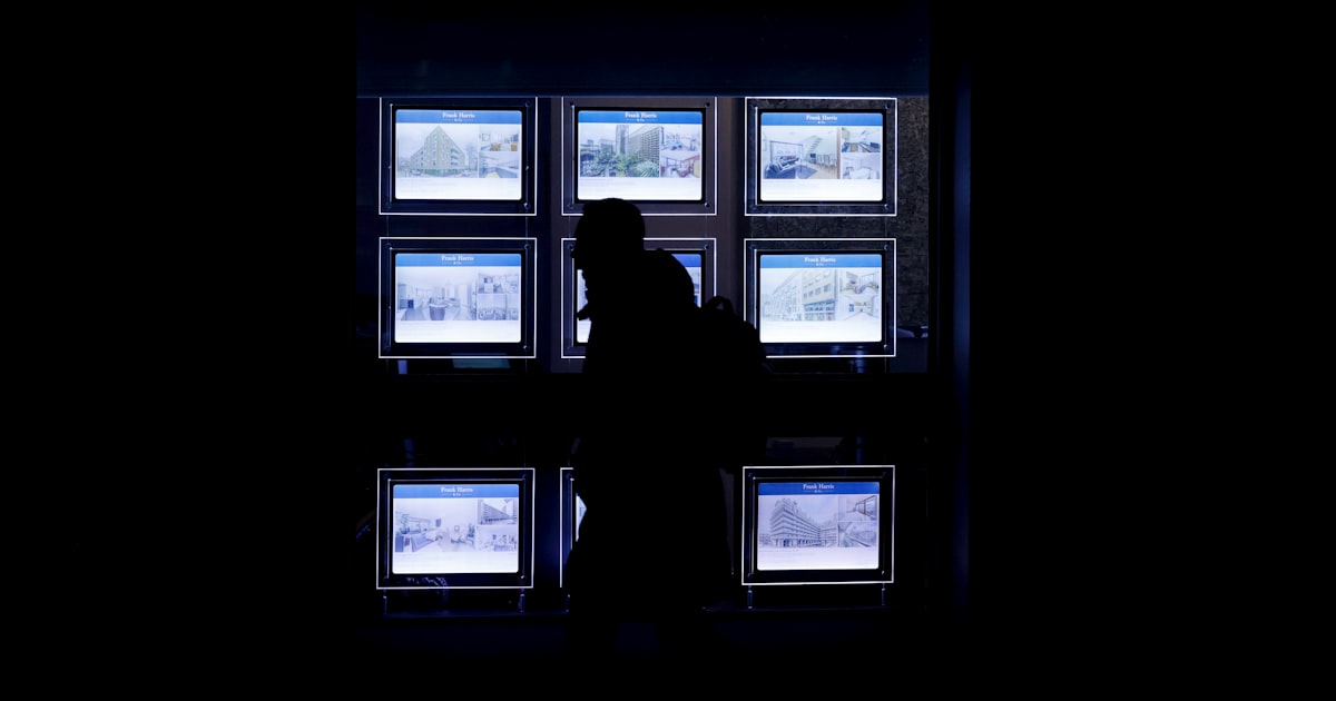 A person standing in front of a window in the dark