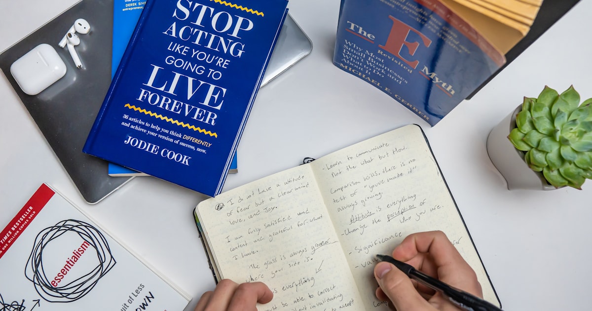 a person is writing on a book with a pen