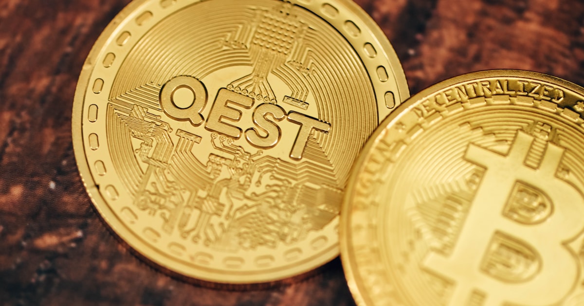 two gold bitcoins sitting on top of a wooden table