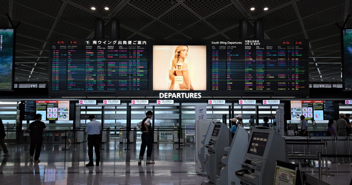 An airport terminal with a lot of electronic screens