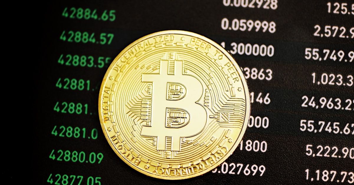 a bit coin sitting on top of a computer screen