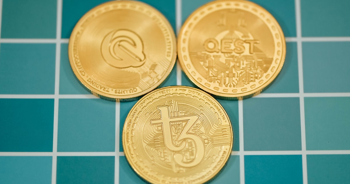 three gold coins sitting on top of a blue tiled floor