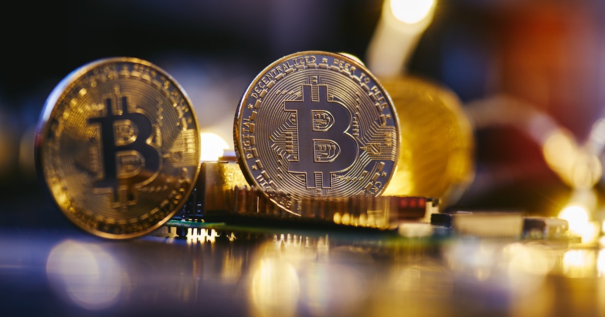 two bitcoins sitting on top of each other on a table
