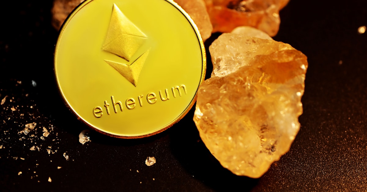a gold ethereum coin sitting on top of a pile of rocks