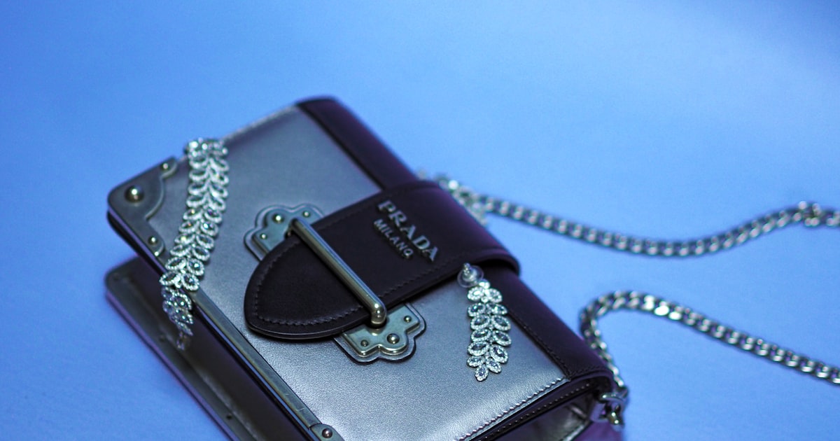 black leather sling bag on blue textile