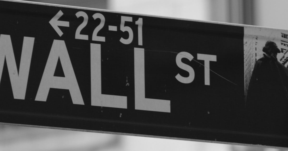 a black and white photo of a wall street sign