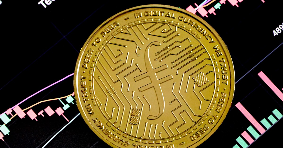 a gold coin sitting on top of a stock chart