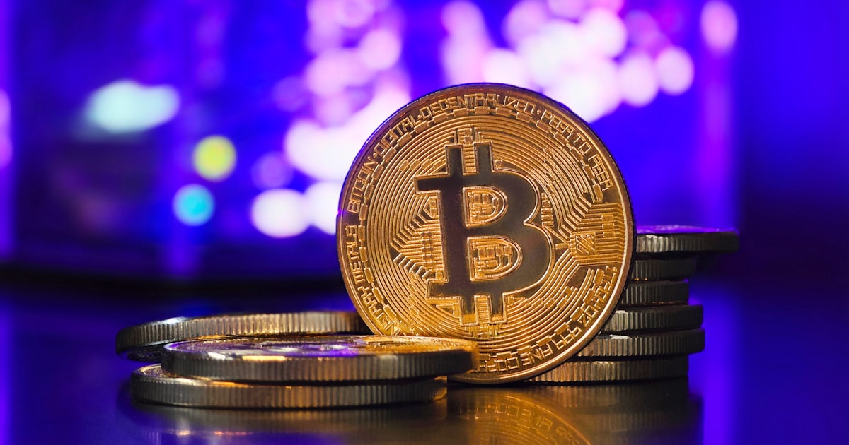 a bit coin sitting on top of a pile of coins
