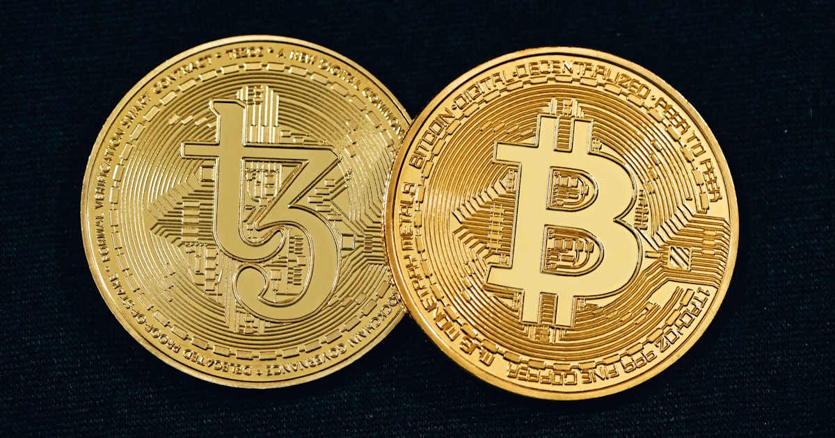 two gold bitcoins sitting side by side on a black surface