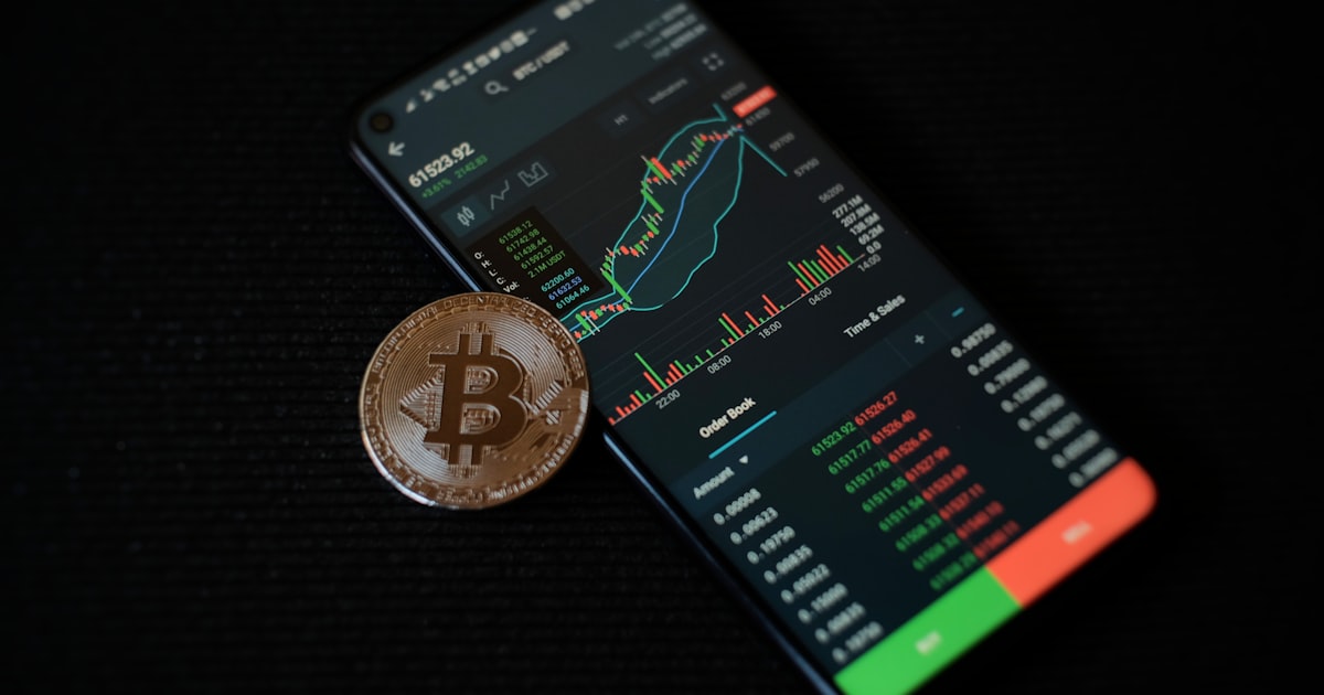 a bitcoin sitting on top of a smart phone