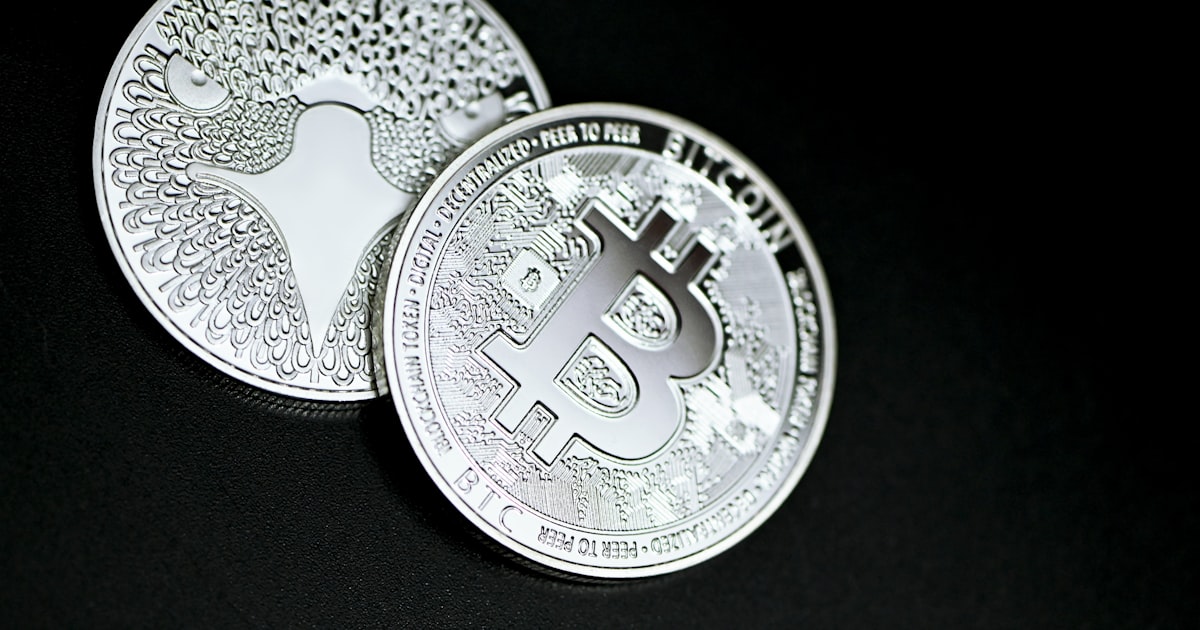 silver round coin on black textile