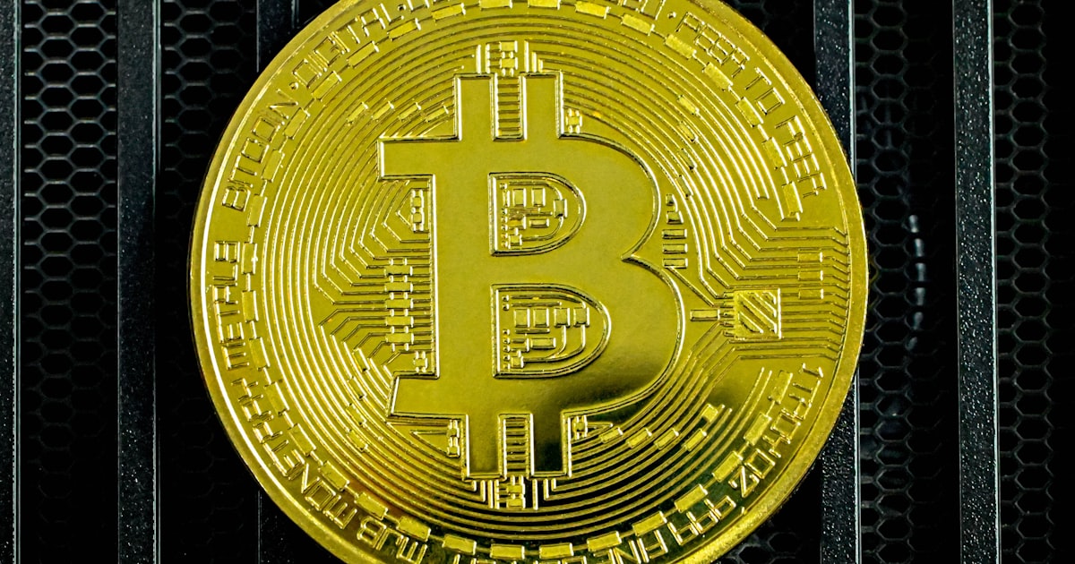 a gold bit coin sitting on top of a metal rack