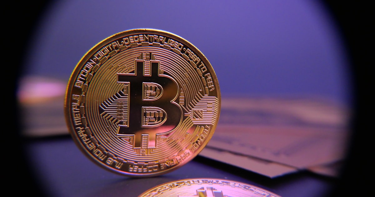 Bitcoin coin displayed on a purple background.
