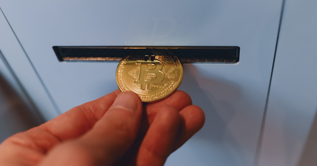 a person is holding a bitcoin in their hand