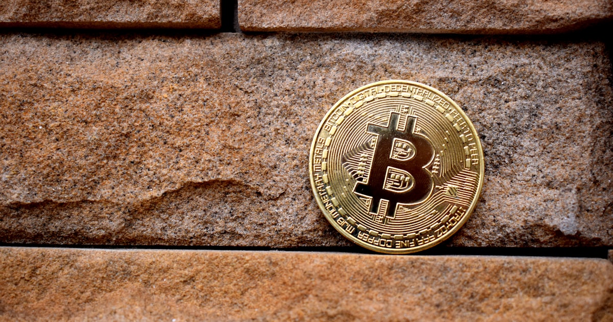 gold round coin on brown brick wall