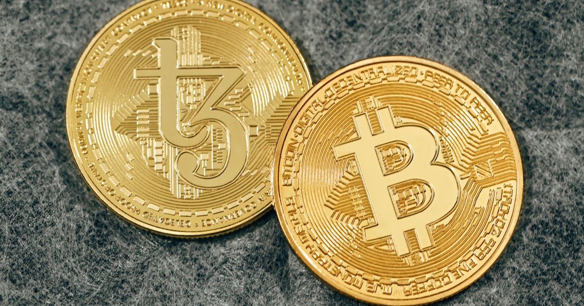 two gold bitcoins sitting side by side