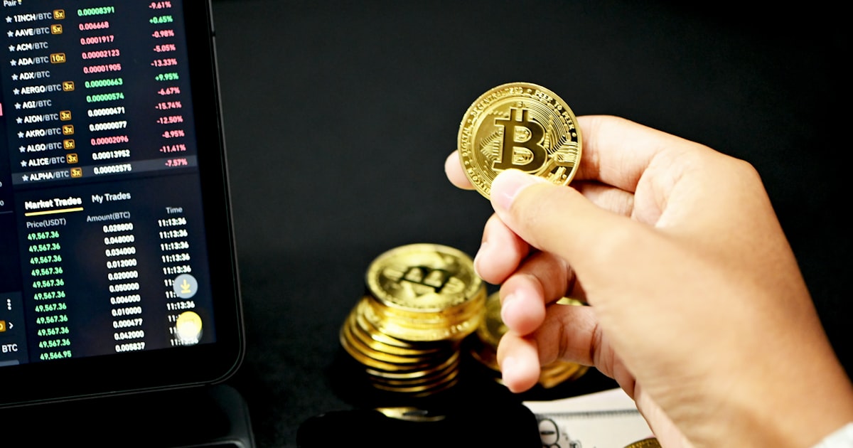 gold round coin on persons hand