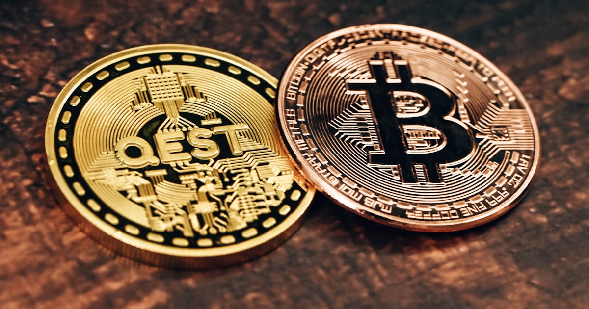 two gold and silver bitcoins sitting on a table