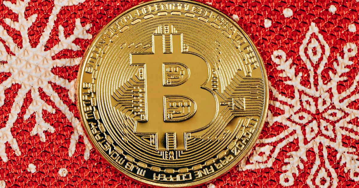 a bit coin sitting on top of a red and white blanket