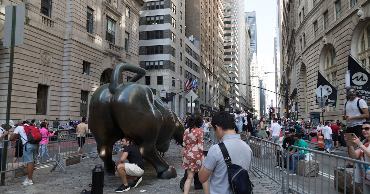 a crowd of people standing around a statue of a bull