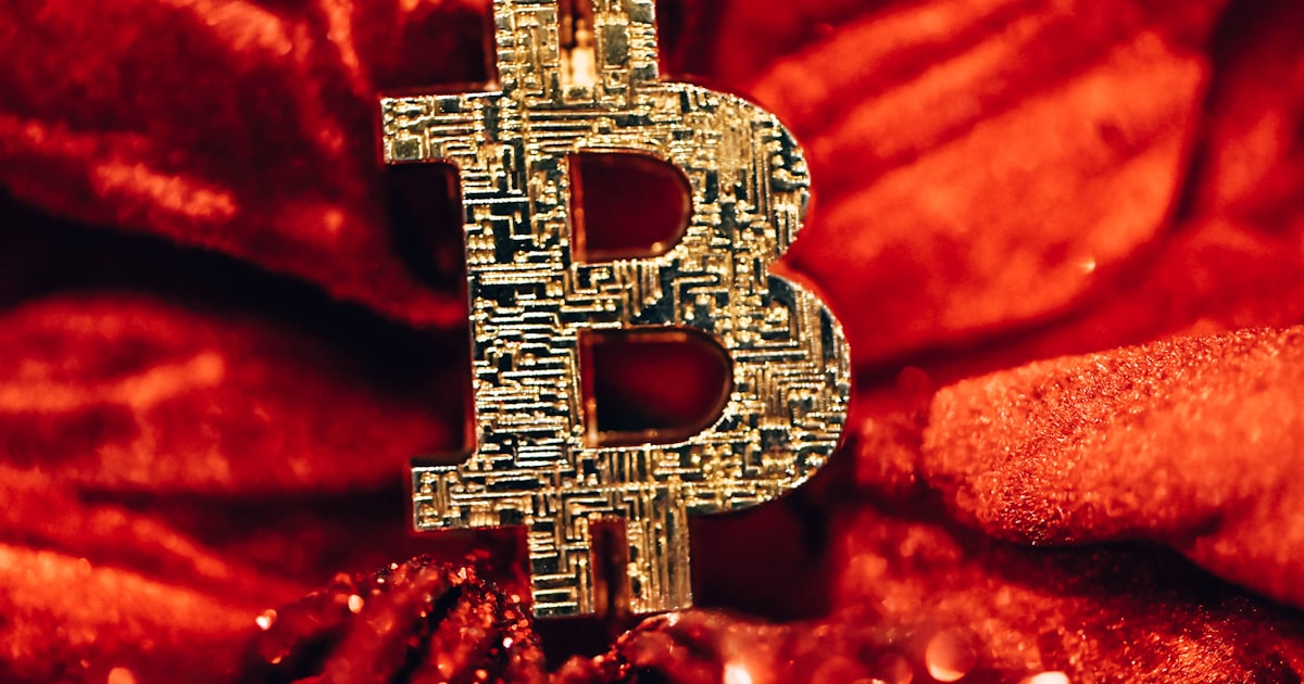 a golden bitcoin sitting on top of a red blanket