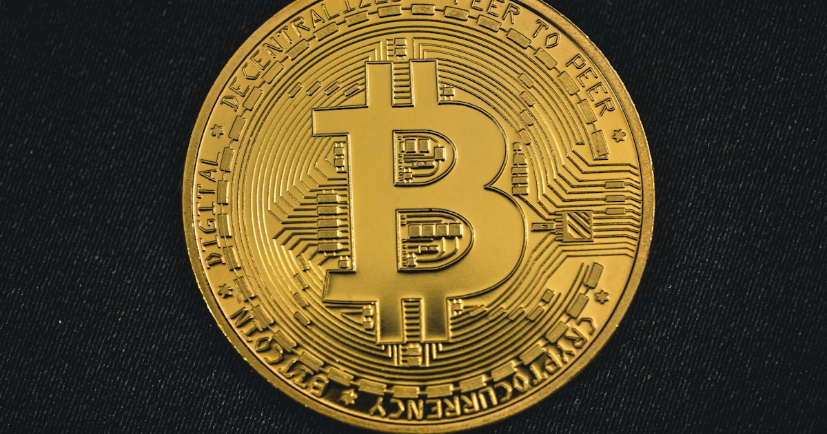 a gold bit coin on a black surface