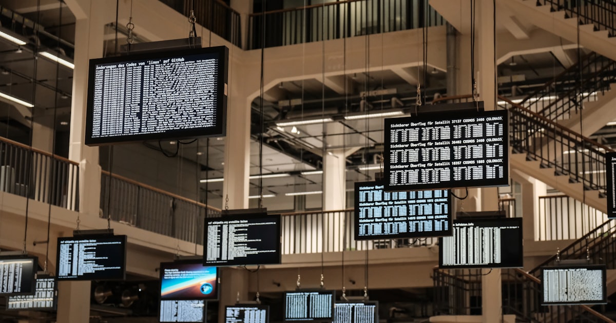 a bunch of television screens hanging from the ceiling
