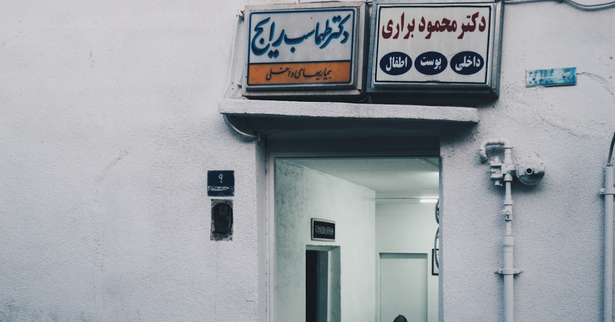 Two signs above a doorway to an open doorway