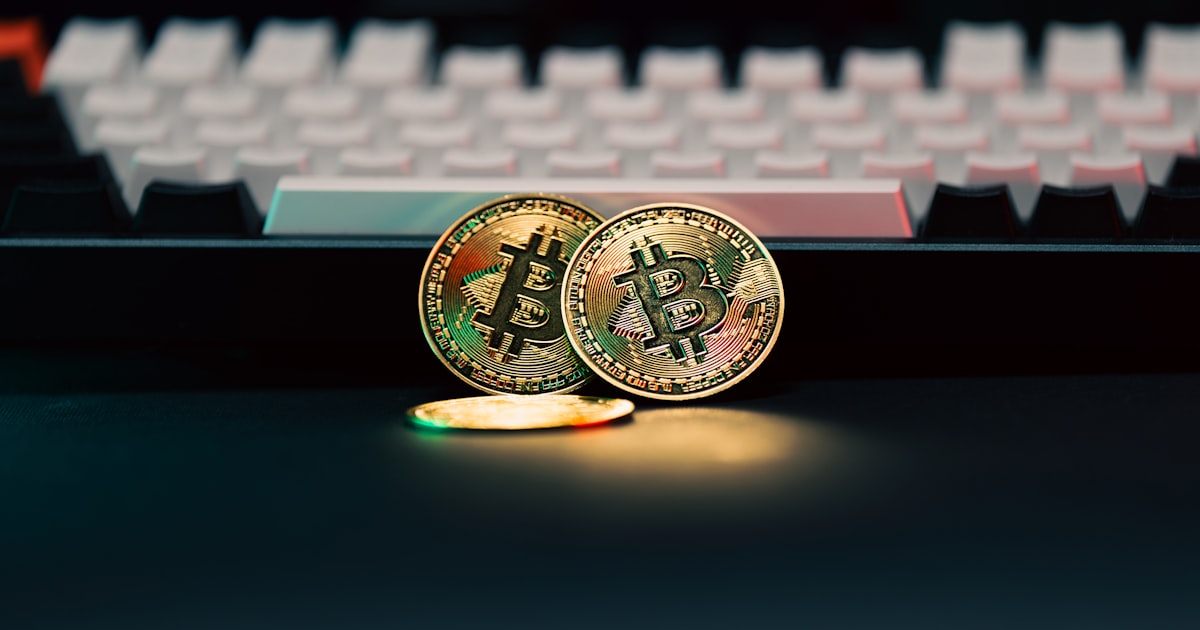 Two bitcoins sitting next to a computer keyboard