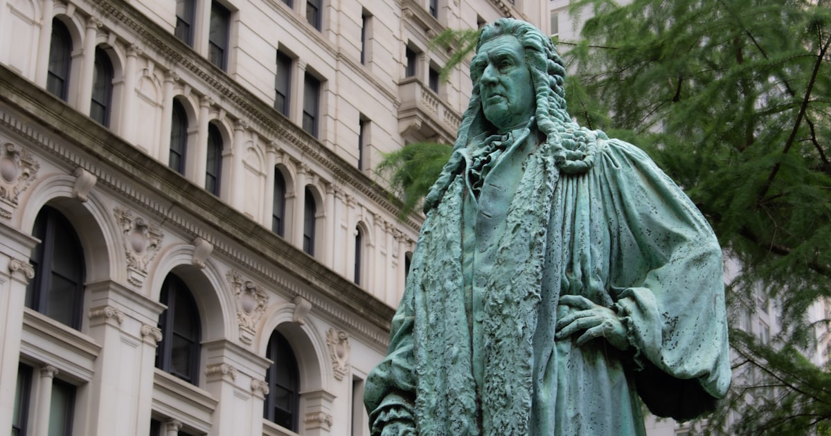 A statue of a man standing in front of a building