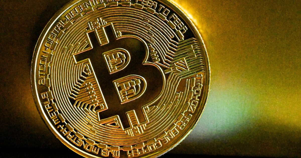 a golden bit coin sitting on top of a table