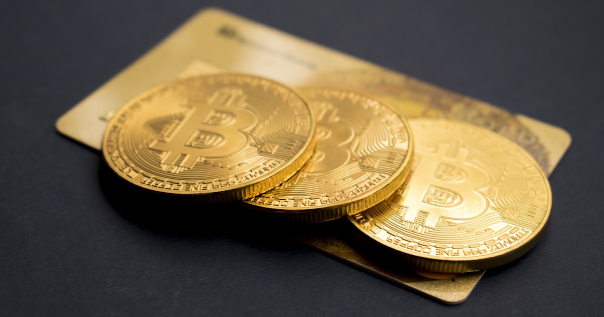 three round gold-colored Bitcoin tokens