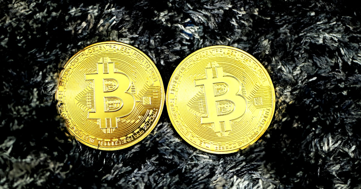 gold round coin on black and white textile