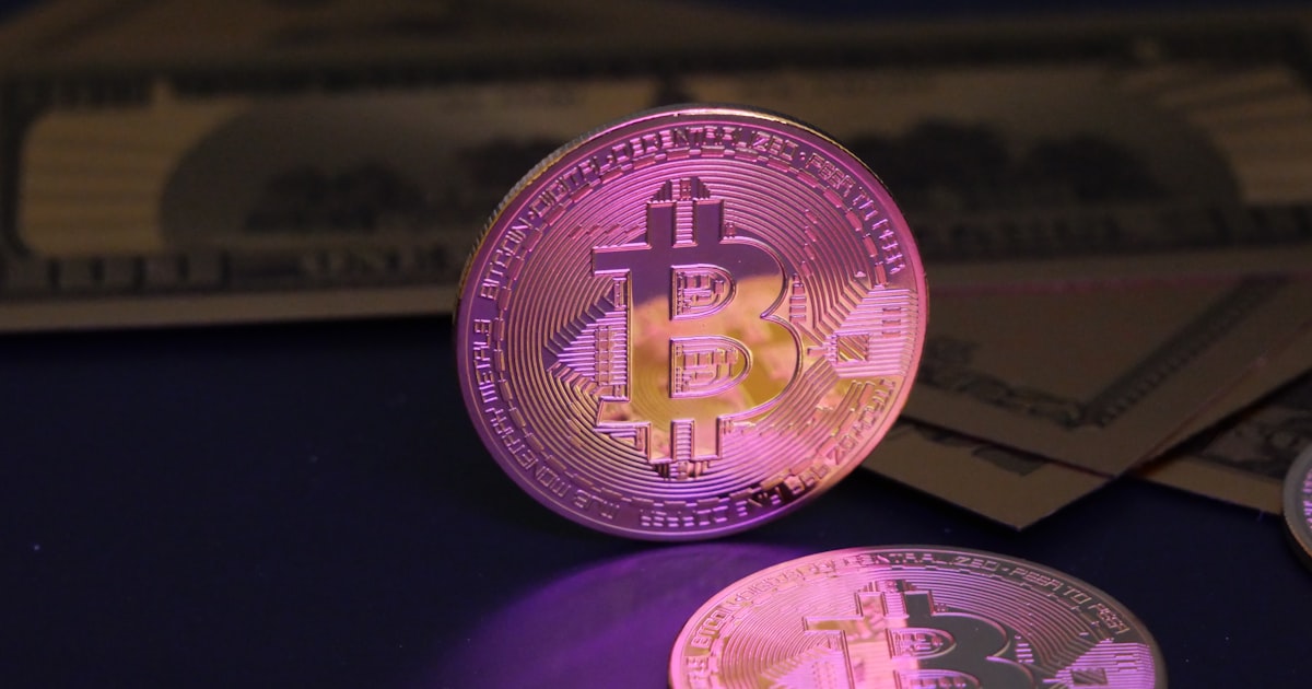 Bitcoin coin and us dollar bills.