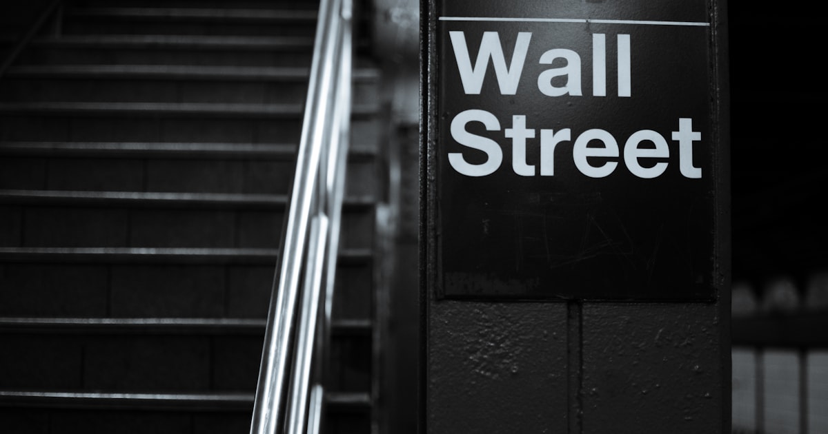 a black and white photo of a wall street sign