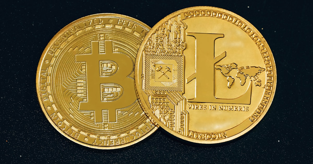 two gold bitcoins sitting side by side on a black surface