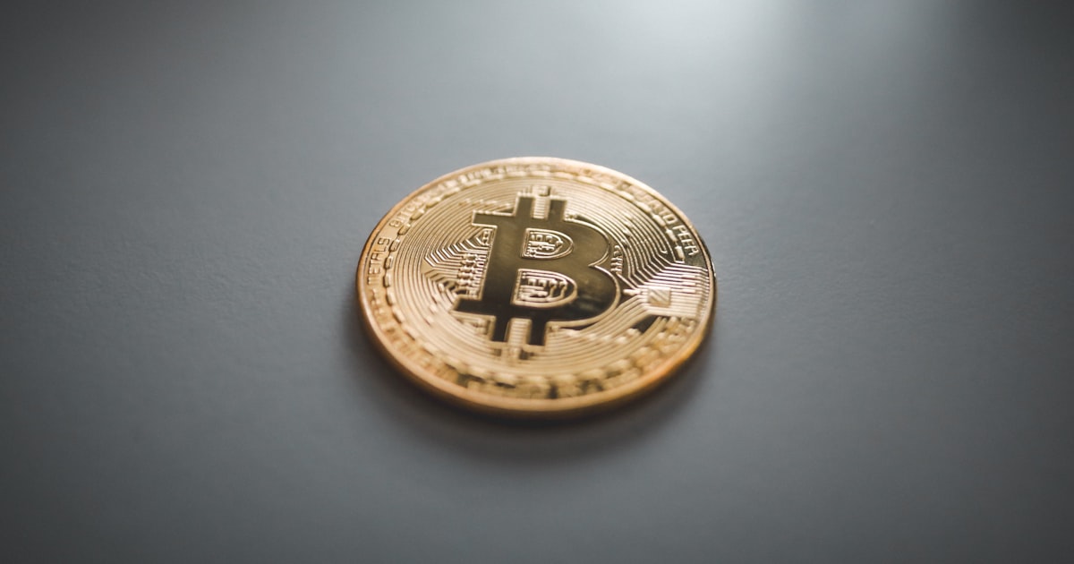 gold round coin on gray surface