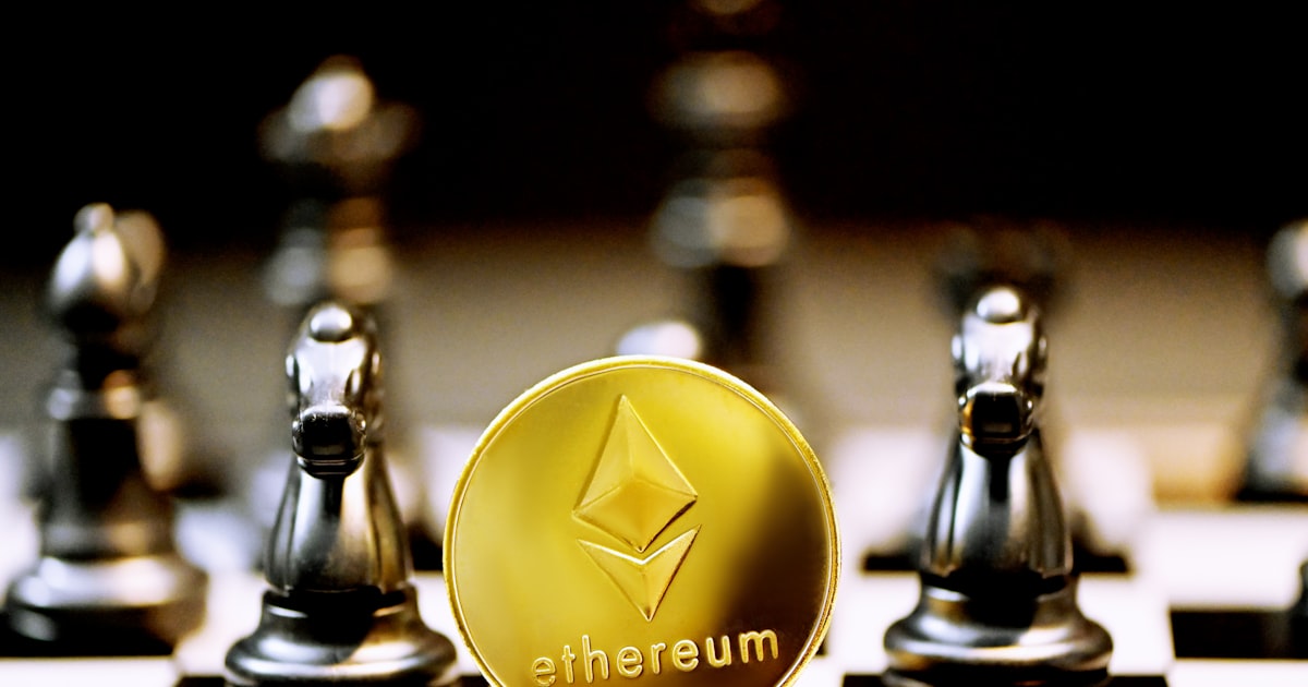 a gold ethereum coin sitting on top of a chess board